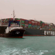 A boat navigates in front of the Ever Green, which turned sideways in Egypt’s Suez Canal, blocking traffic in a crucial East-West waterway for global shipping.